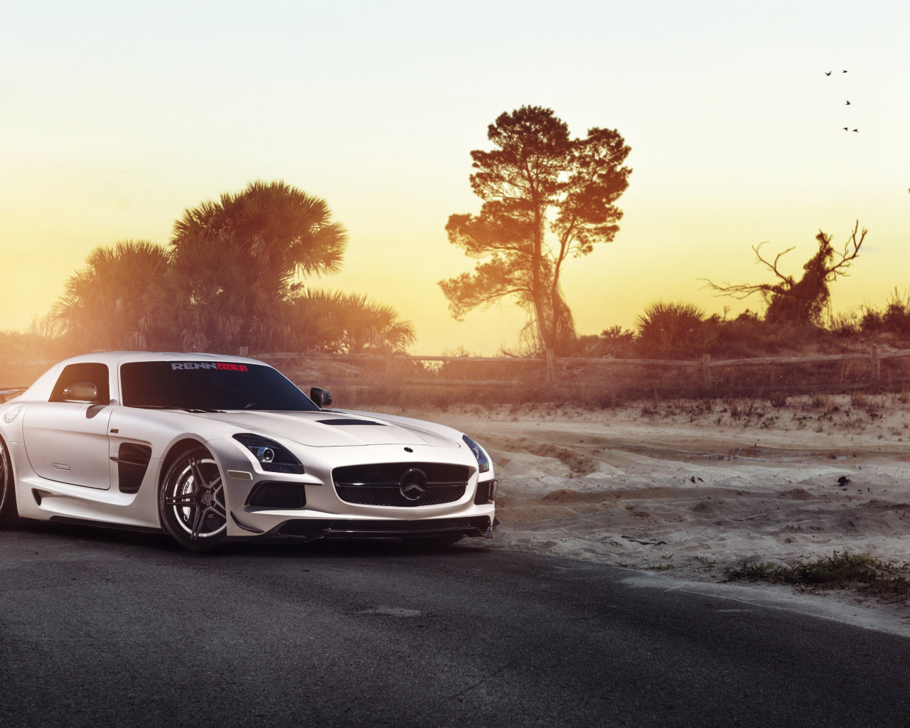 Автомобиль Mercedes-Benz SLS на фоне заката