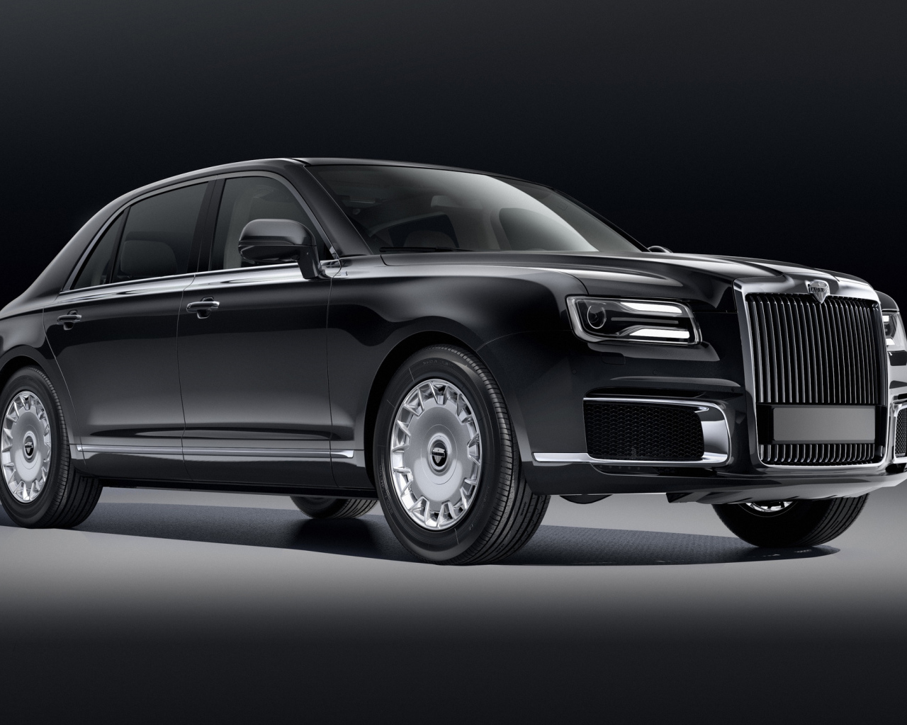 Черный автомобиль Aurus Sena 2018 года на сером фоне