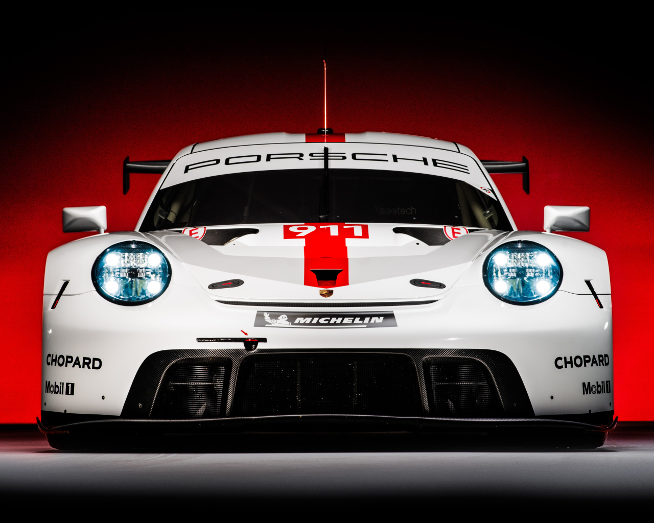 Спортивный автомобиль Porsche 911 RSR 2019 года на красном фоне