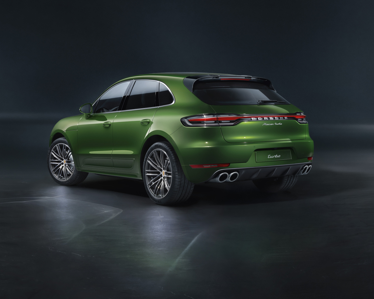 Зеленый автомобиль Porsche Macan Turbo 2019 года вид сзади