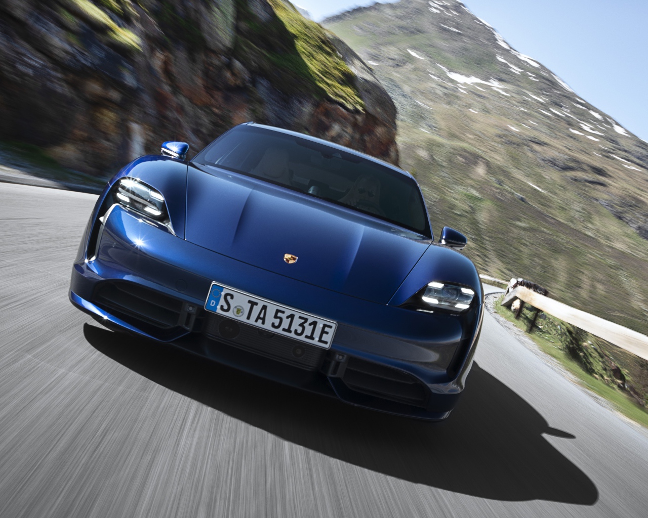 Синий автомобиль Porsche Taycan Turbo 2019 года на фоне гор