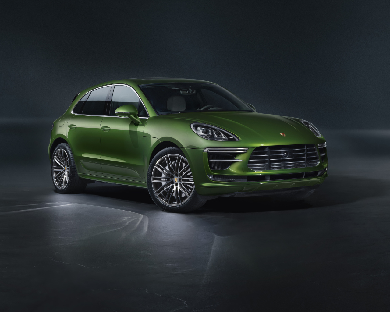 Зеленый автомобиль Porsche Macan Turbo 2019 года на сером фоне