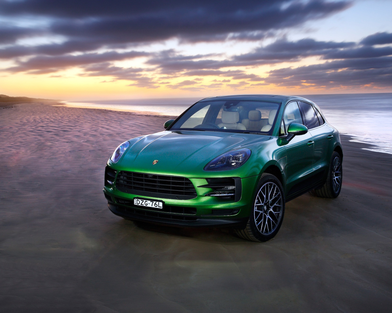 Зеленый автомобиль Porsche Macan S 2019 года на берегу океана 
