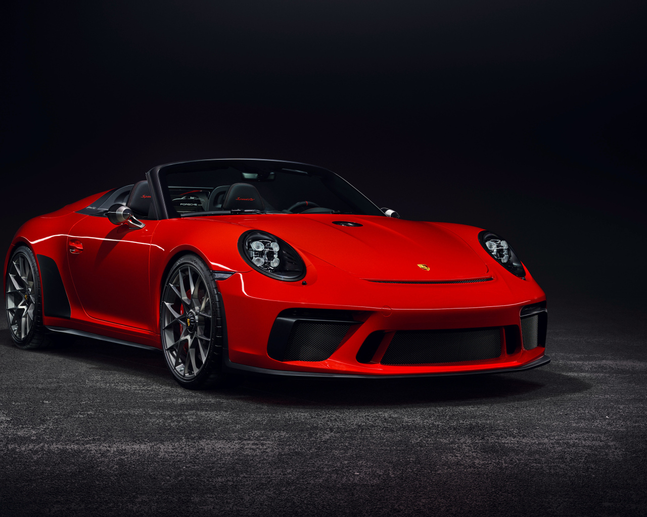 Красный кабриолет Porsche 911  на сером фоне