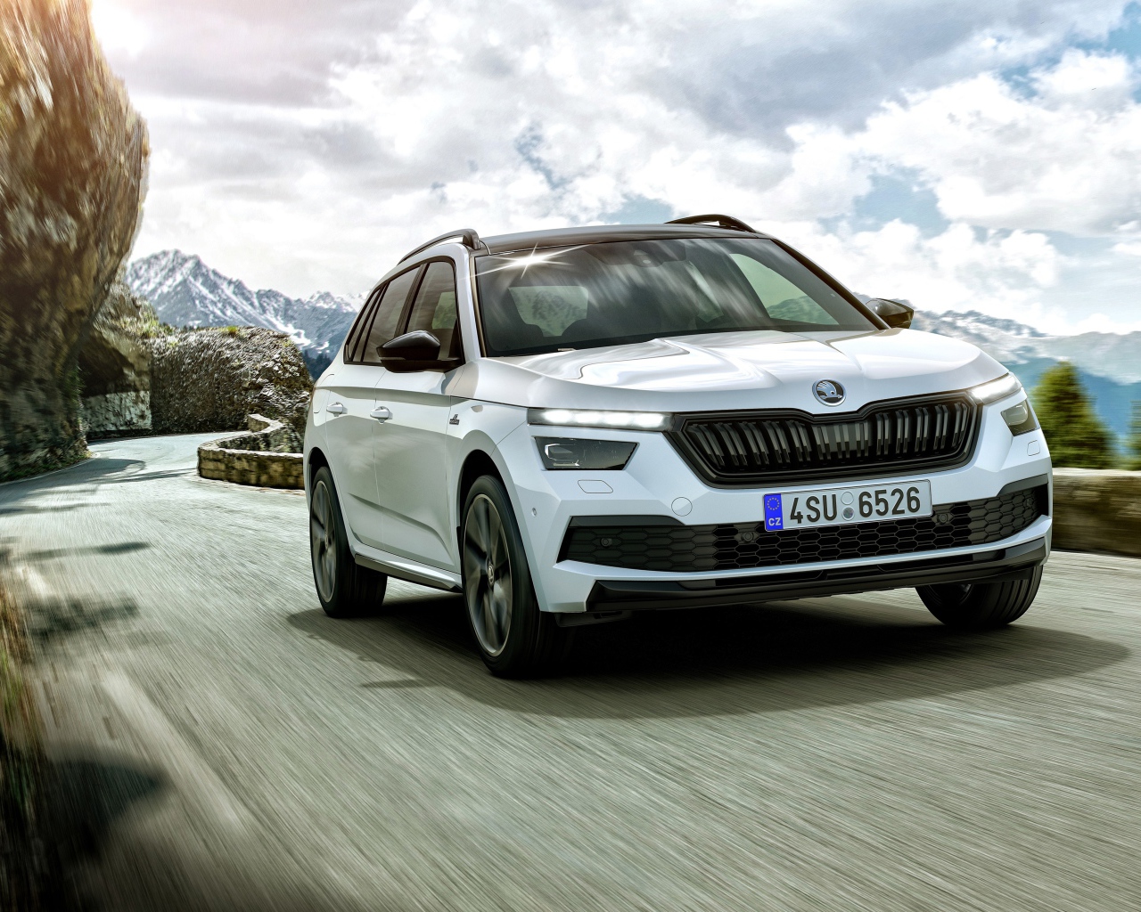 Белый внедорожник Skoda Kamiq Monte Carlo 2019 года на фоне неба в горах