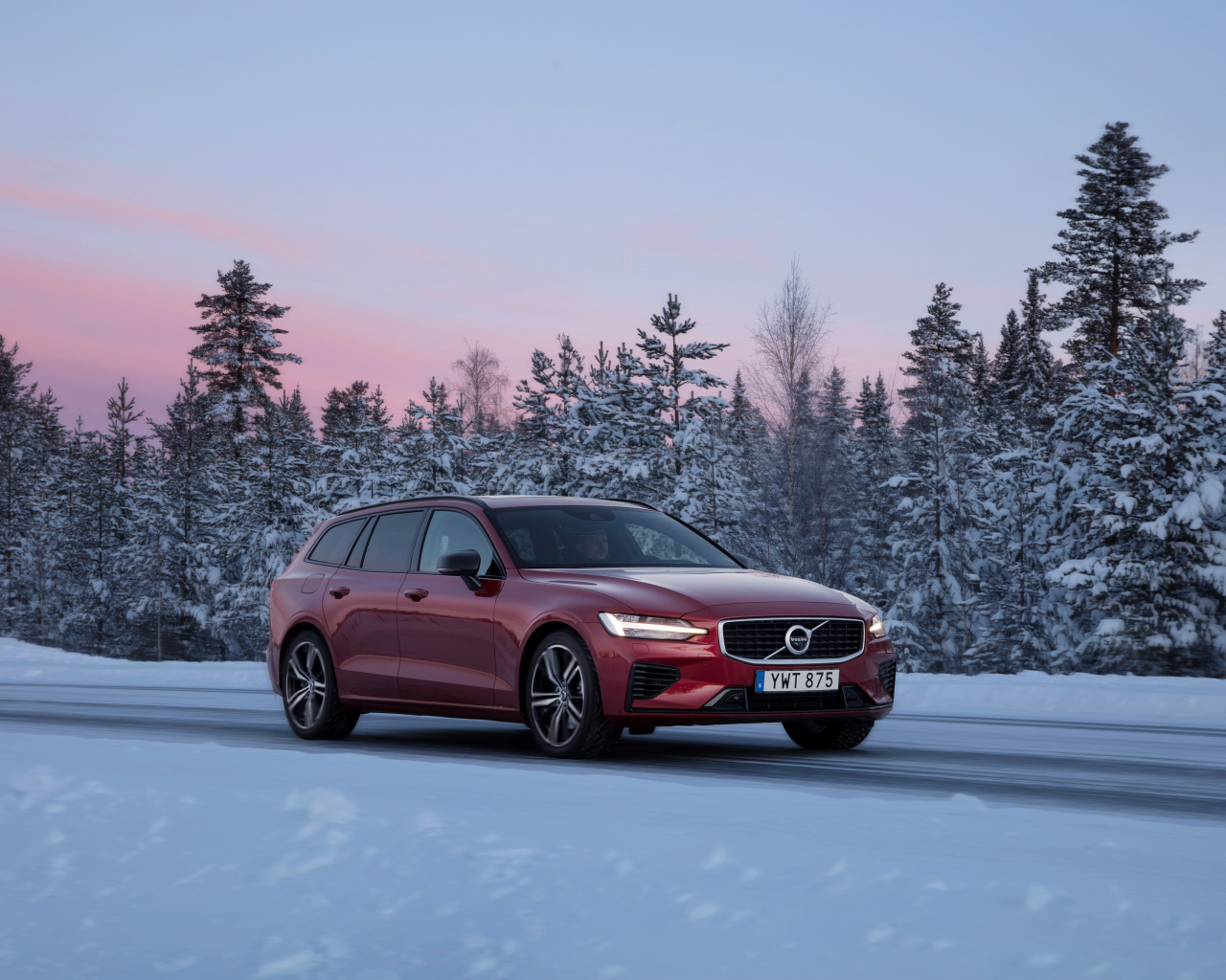 Красный автомобиль Volvo V60 на зимней дороге