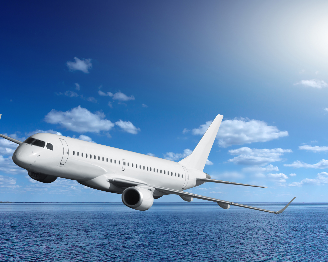 Большой белый пассажирский самолет летит над морем