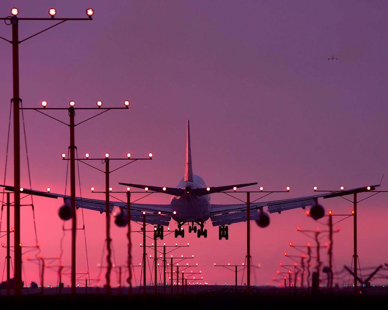 Пассажирский самолет идет на посадку на закате 