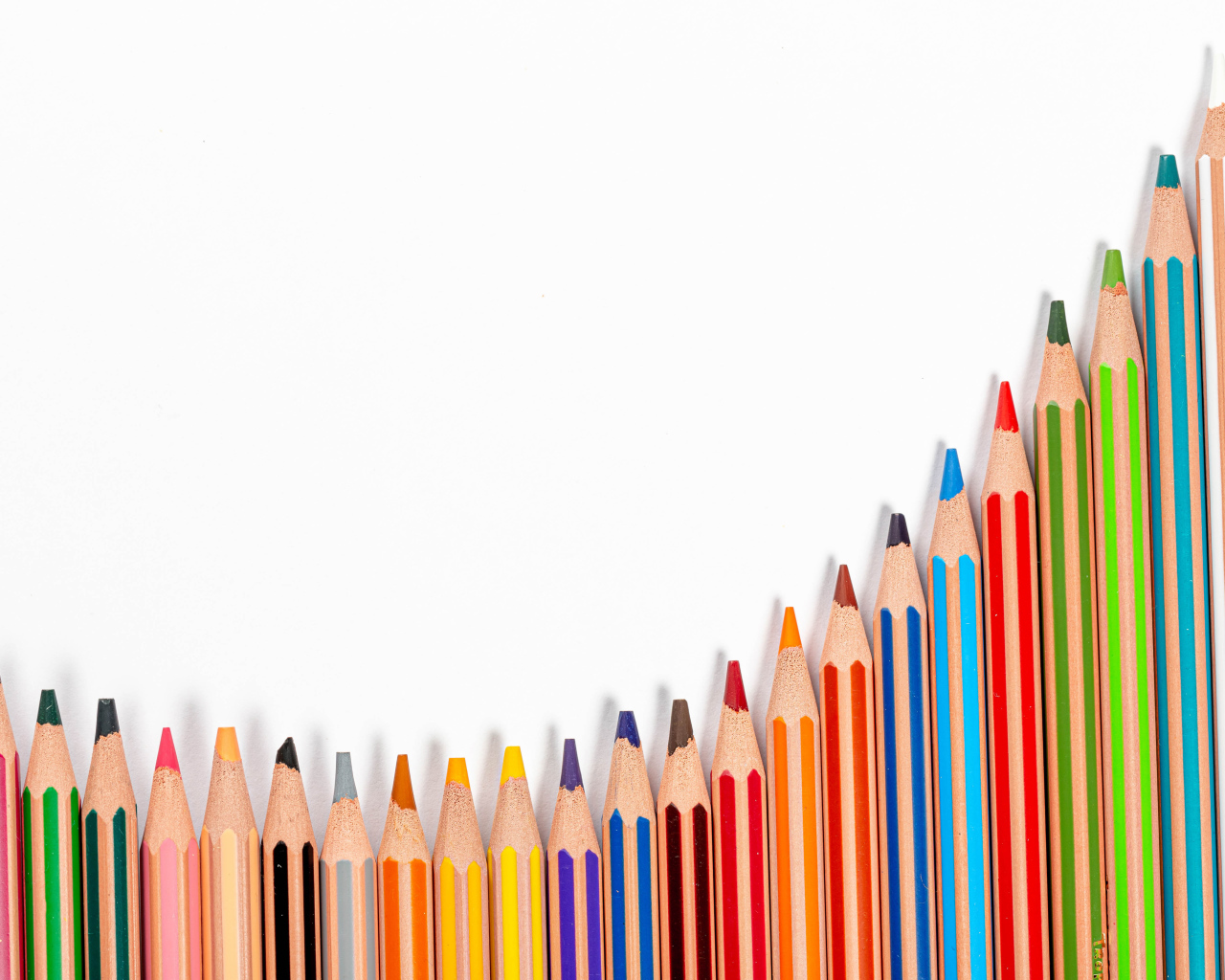 Много разноцветных карандашей на белом фоне