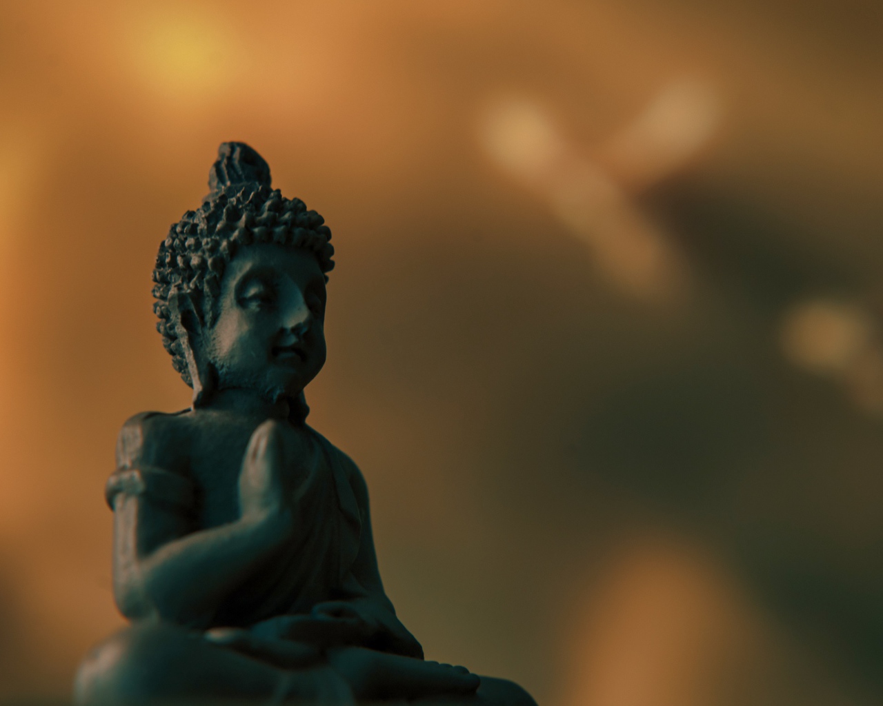 Статуэтка Будда на коричневом фоне крупным планом