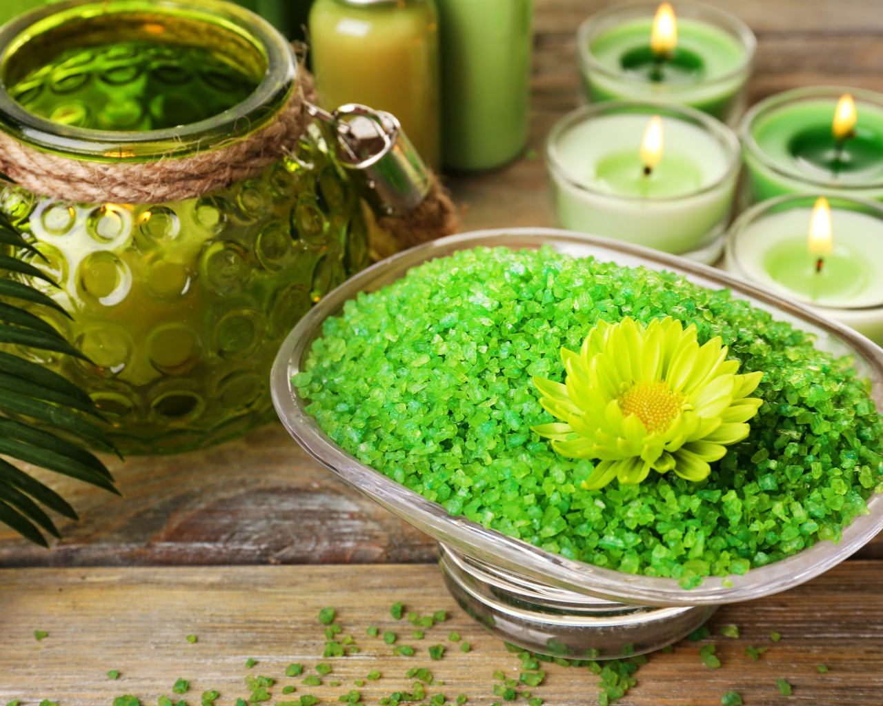Зеленая ароматная морская соль на столе с зажженными свечами