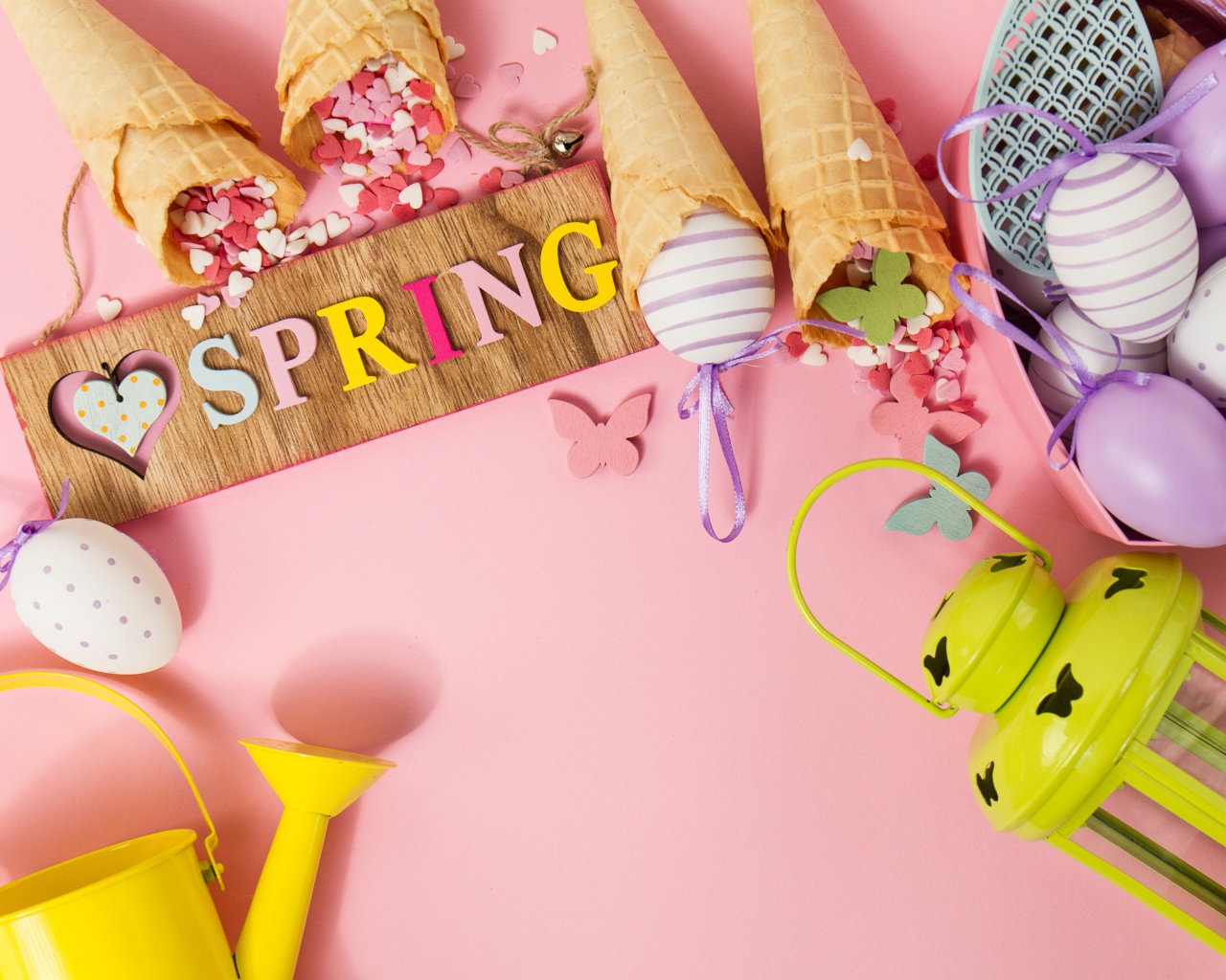 Надпись весна с вафельными рожками и яйцами на розовом фоне