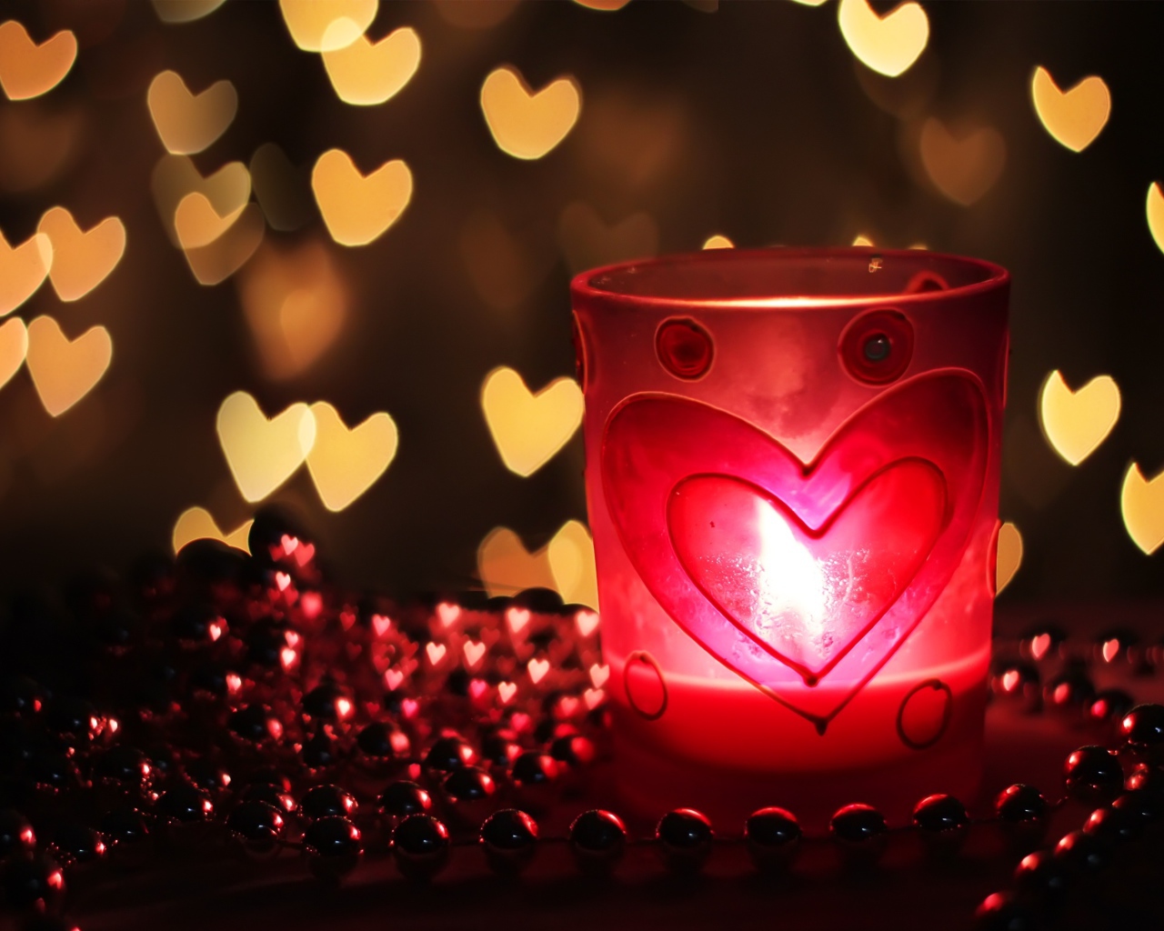 Зажженная свеча на столе с бусами 