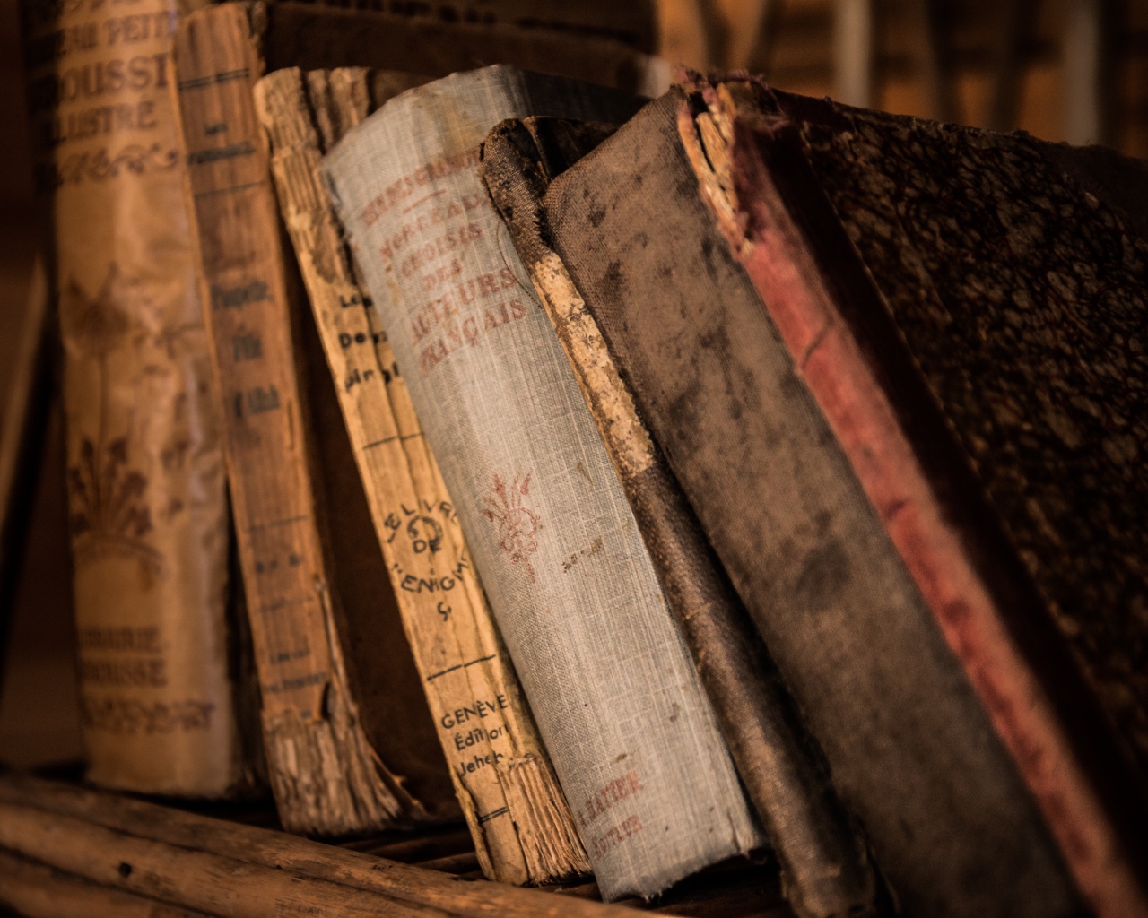 Старые потрепанные книги лежат на полке