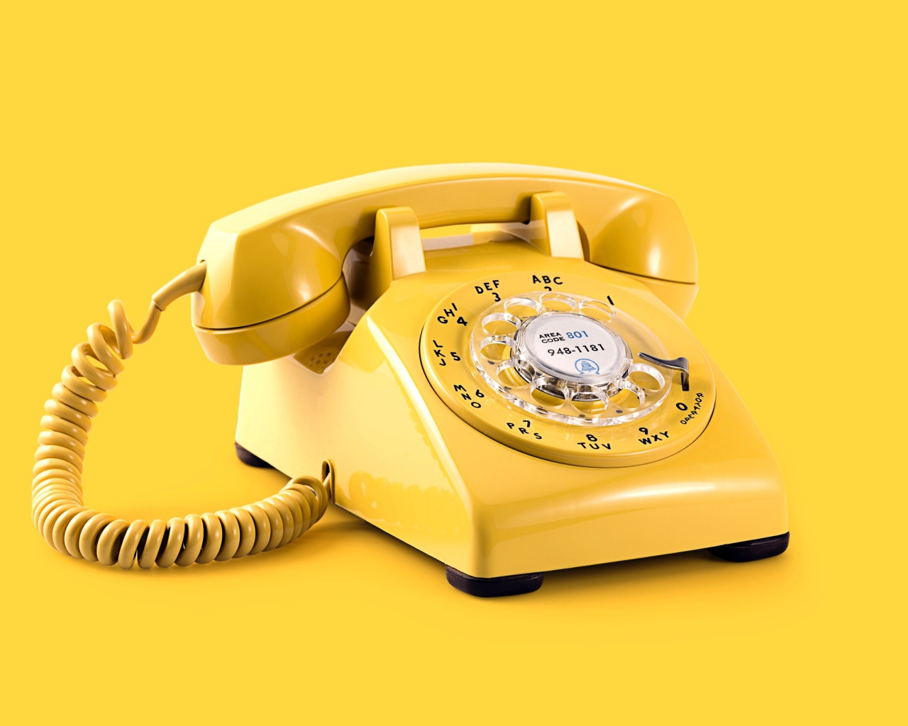 Старый желтый телефон на желтом фоне