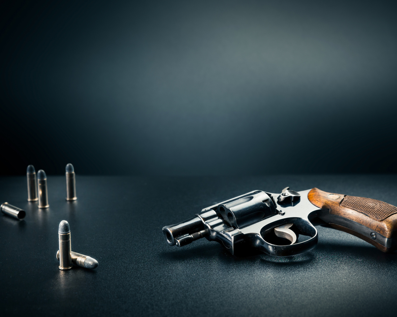 Револьвер с пулями на сером фоне