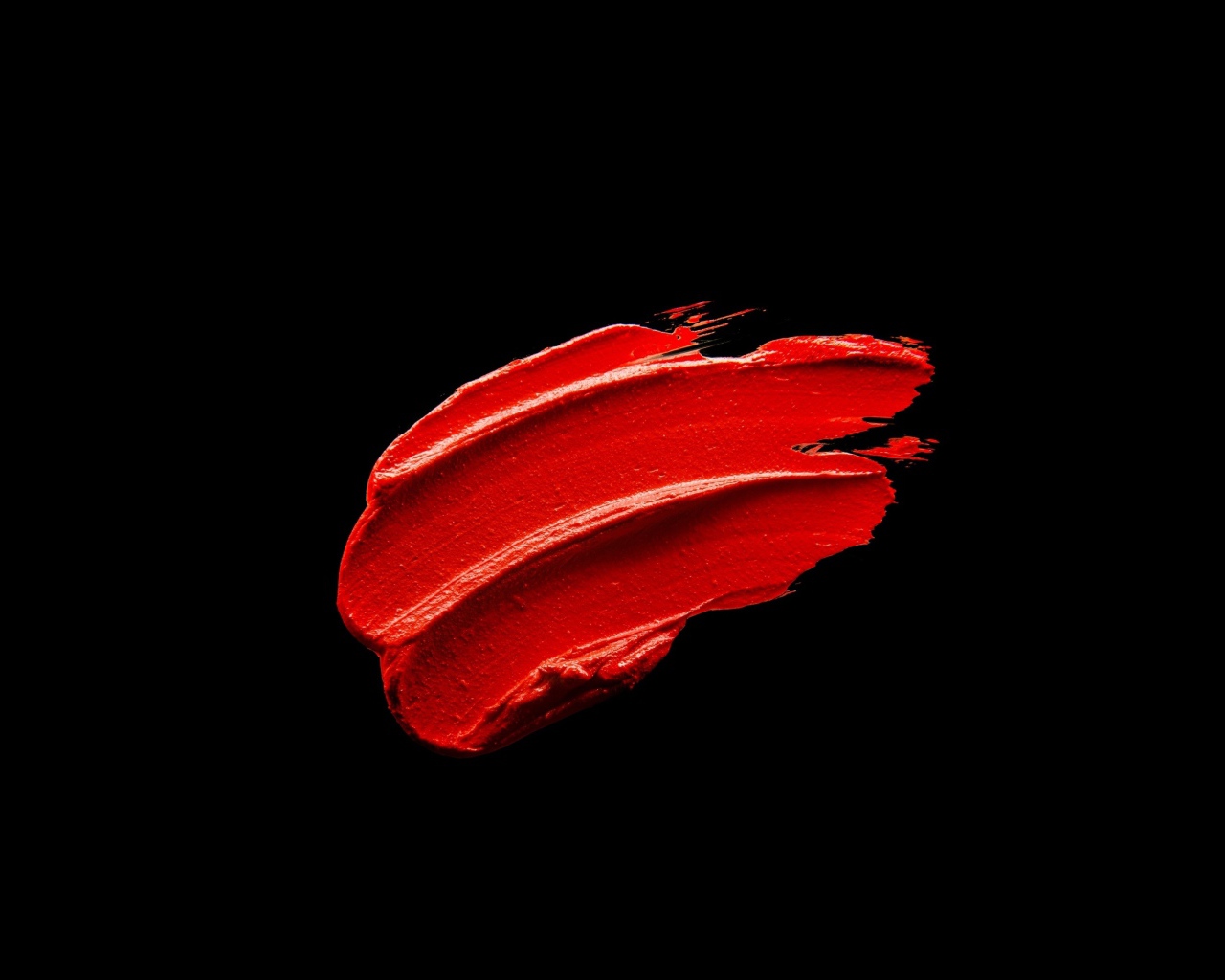 Мазок красной краски на черном фоне