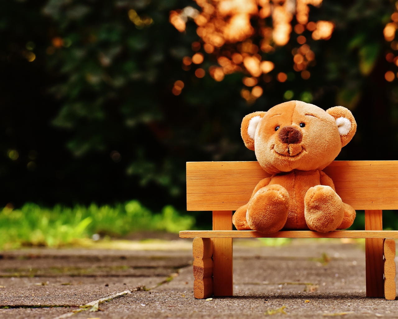 Медвежонок Тедди сидит на деревянной лавке