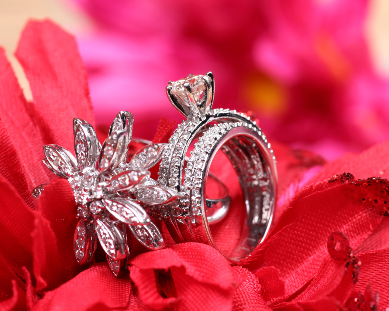 Два кольца с камнями лежат на цветке 