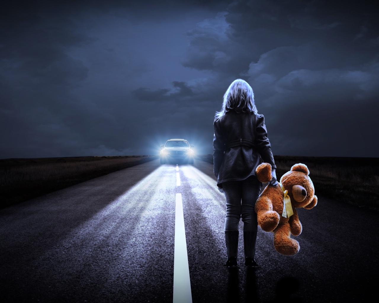 Девушка стоит на дороге с игрушечным медведем