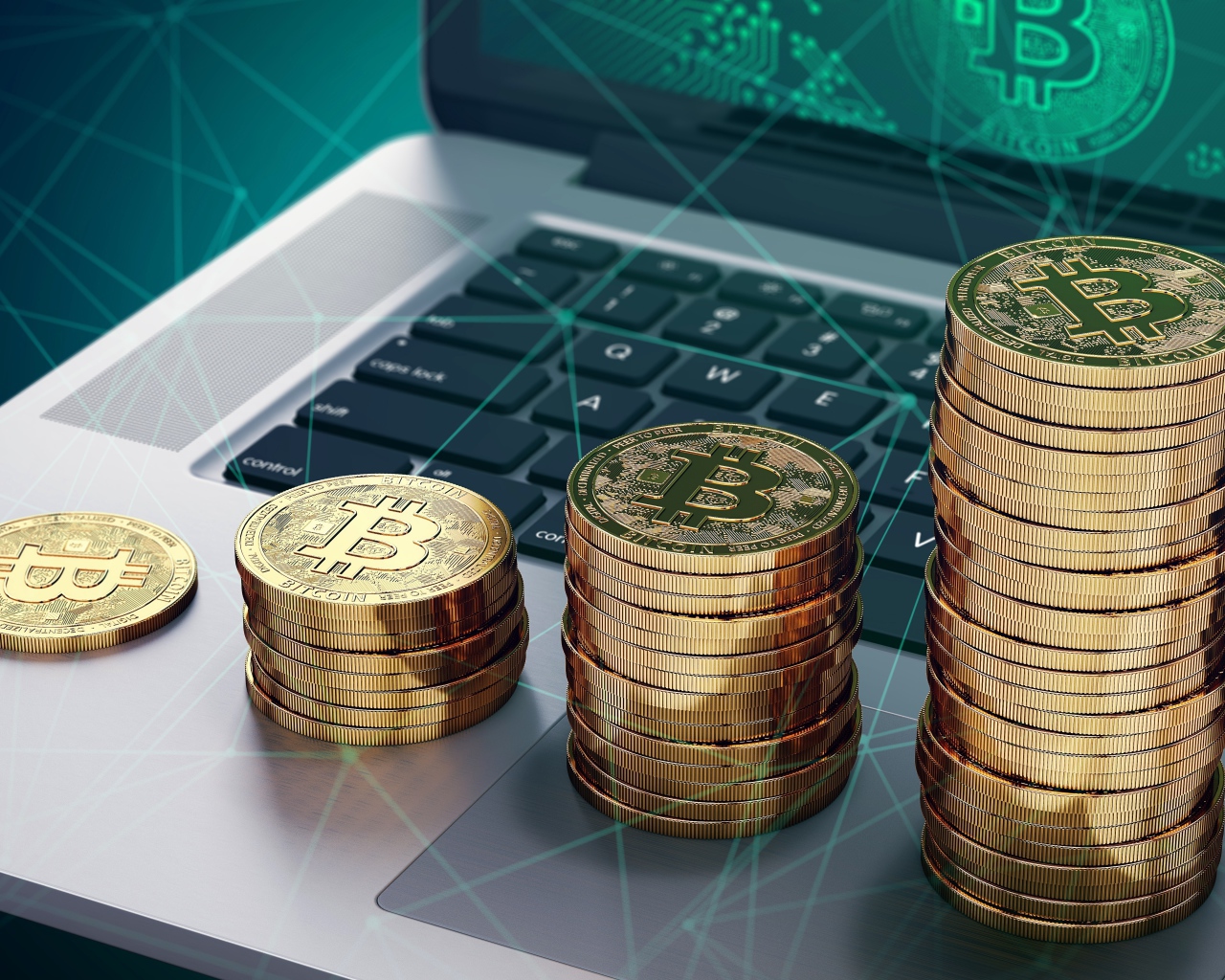 Золотые монеты Биткоин лежат на ноутбуке
