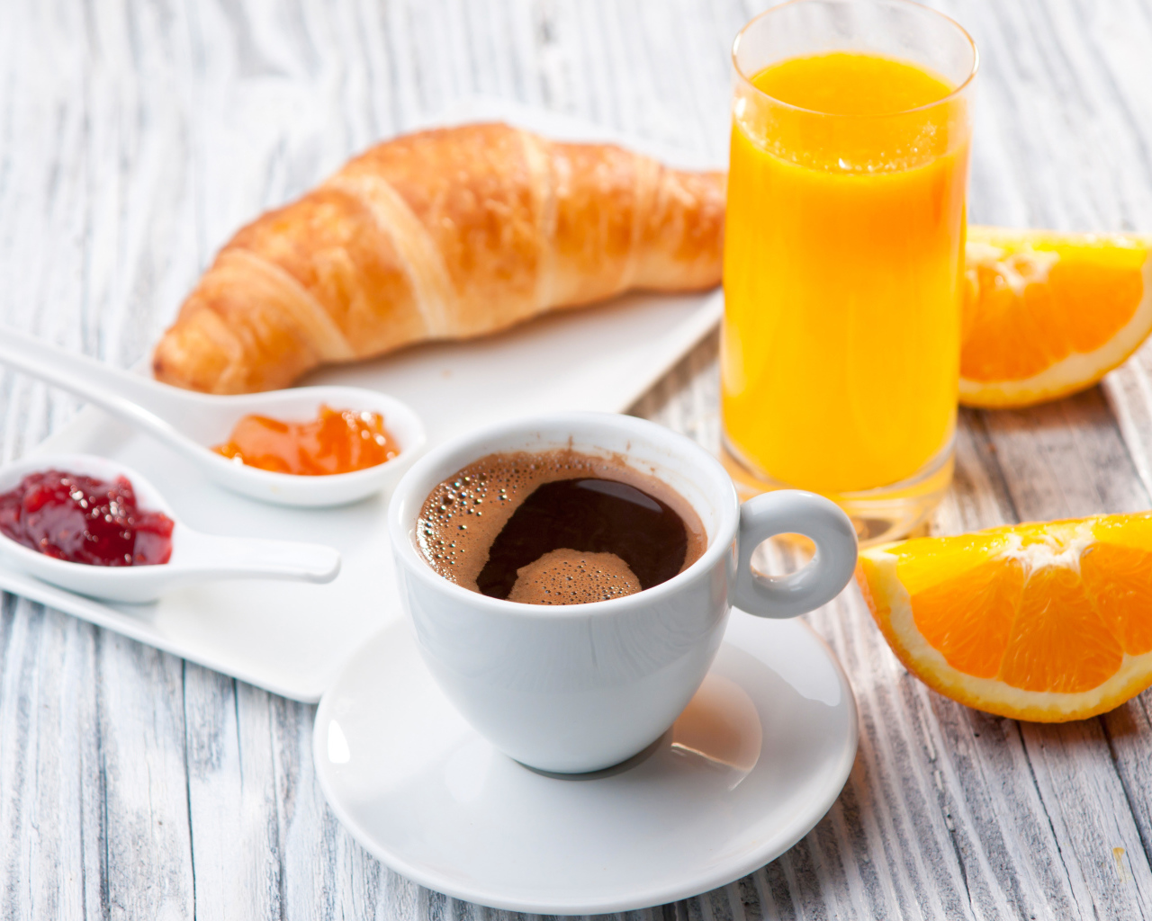 Чашка кофе на столе с соком и круассаном