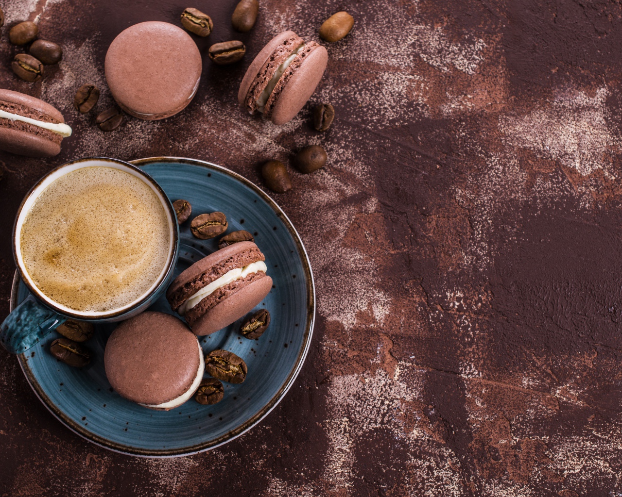 Чашка кофе с шоколадными макарунами на столе