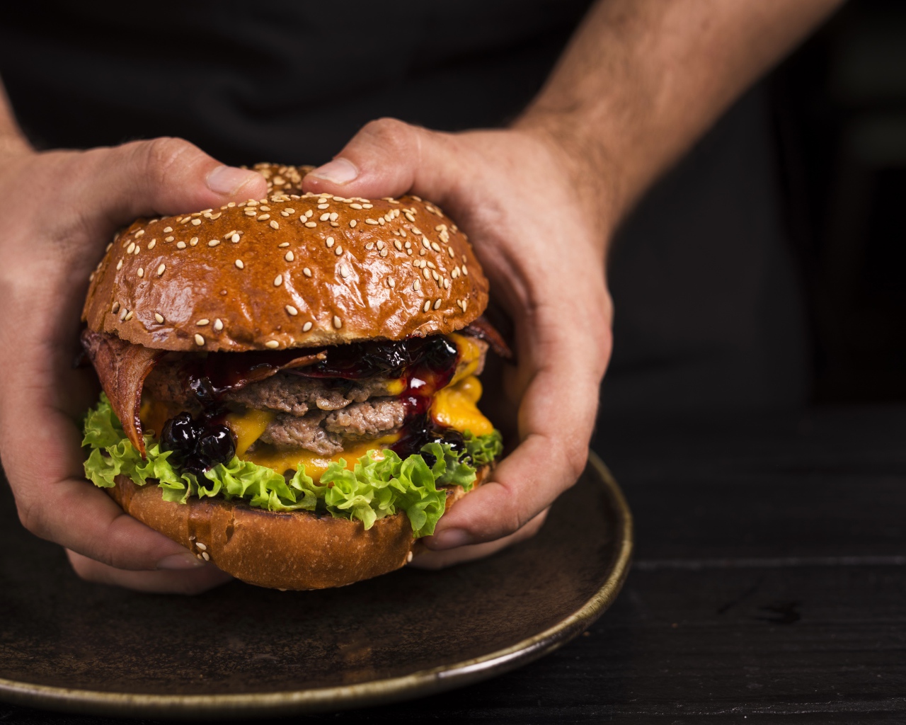 Большой сочный гамбургер в руках