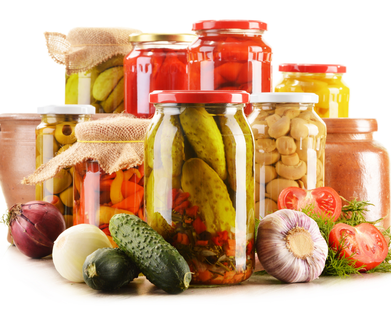 Консервация в банках на белом фоне с овощами