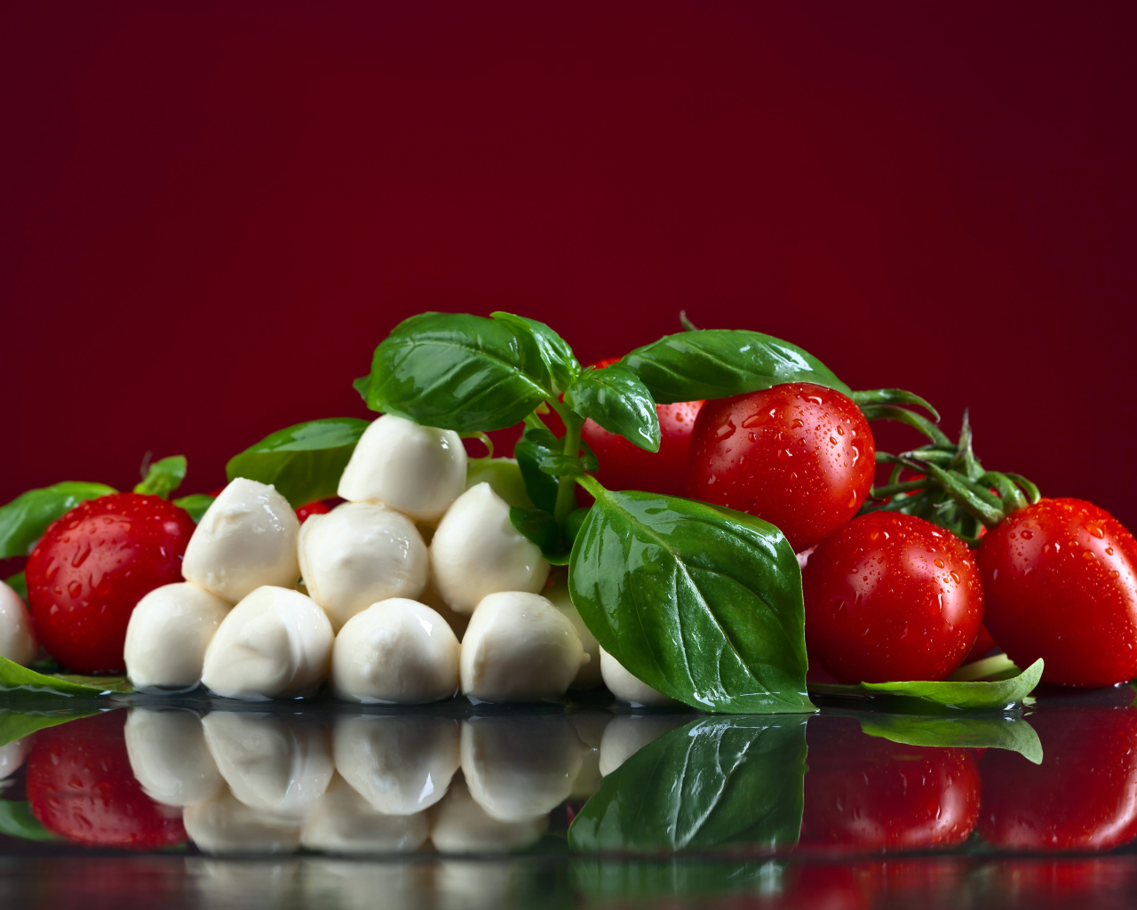 Сыр на столе с зеленью базилика и красными помидорами