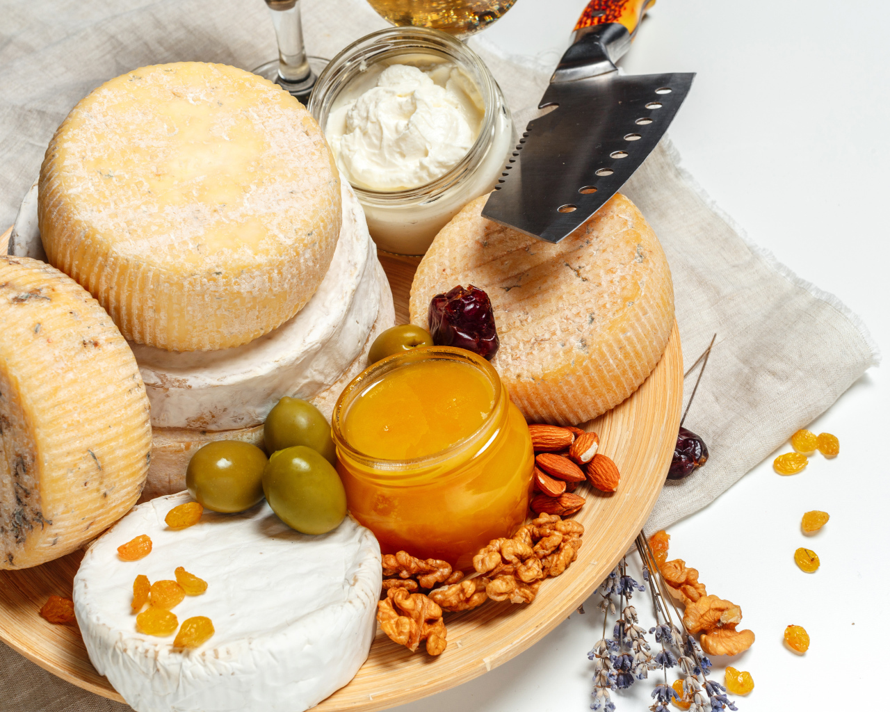 Сыр с плесенью на тарелке оливками, орехами и медом 