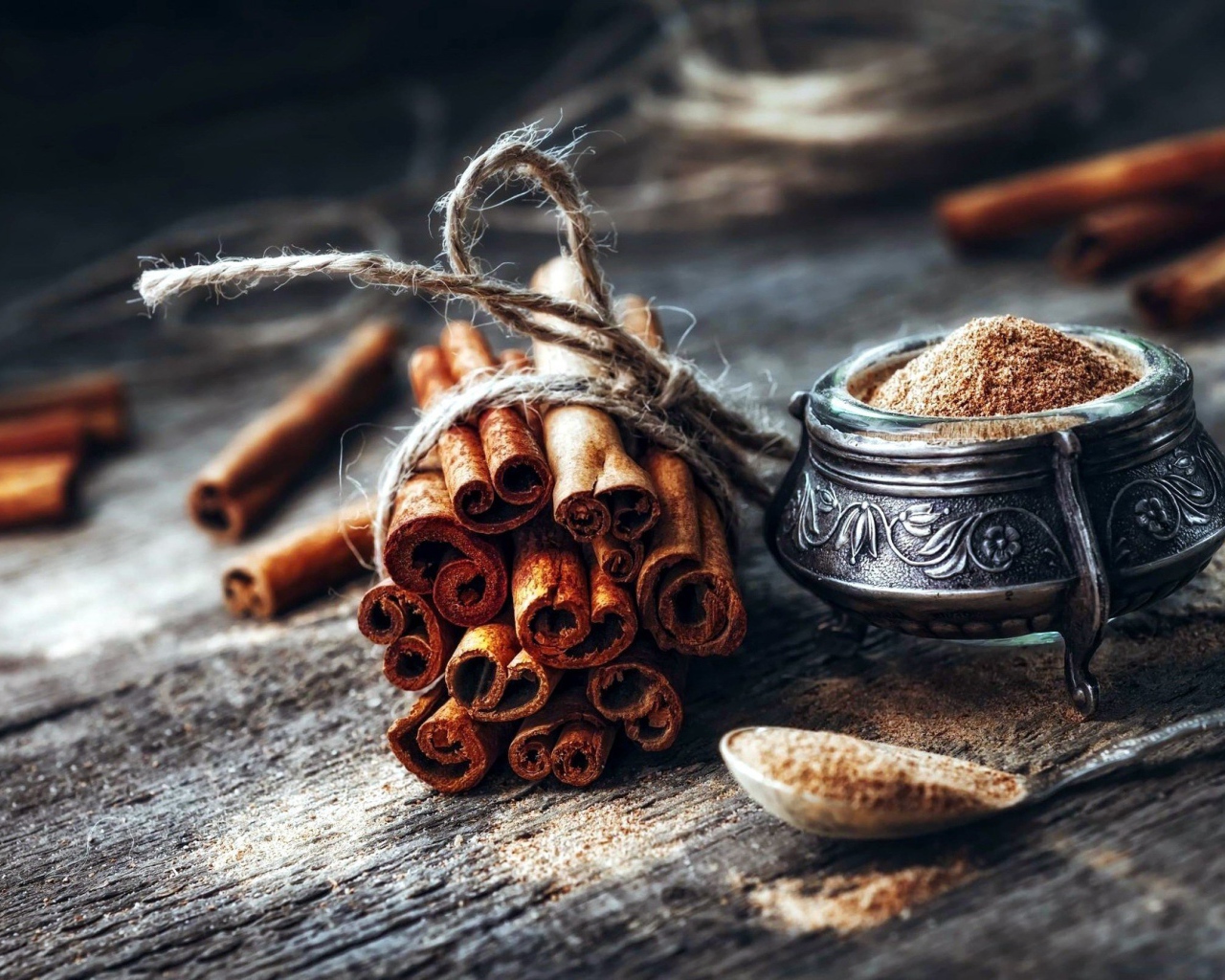 Палочки корицы на столе с молотой корицей