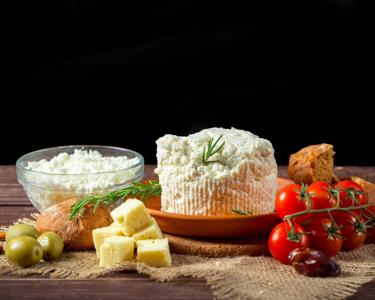 Творог на столе с сыром, хлебом и помидорами