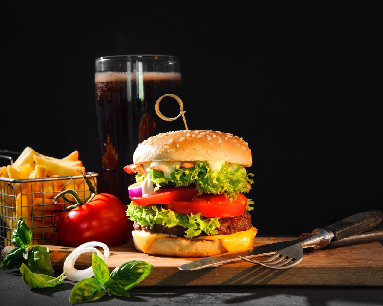 Вкусный аппетитный гамбургер на столе с пивом и картофелем фри