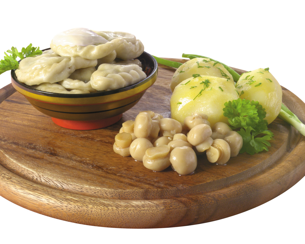 Вареники с грибами и вареной картошкой на деревянной доске на белом фоне