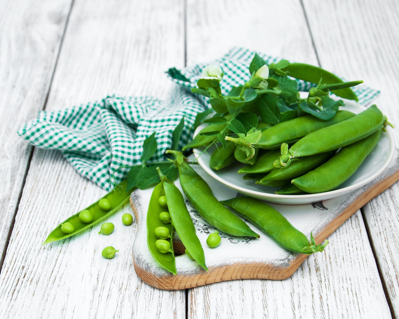 Свежий зеленый горох на столе с полотенцем