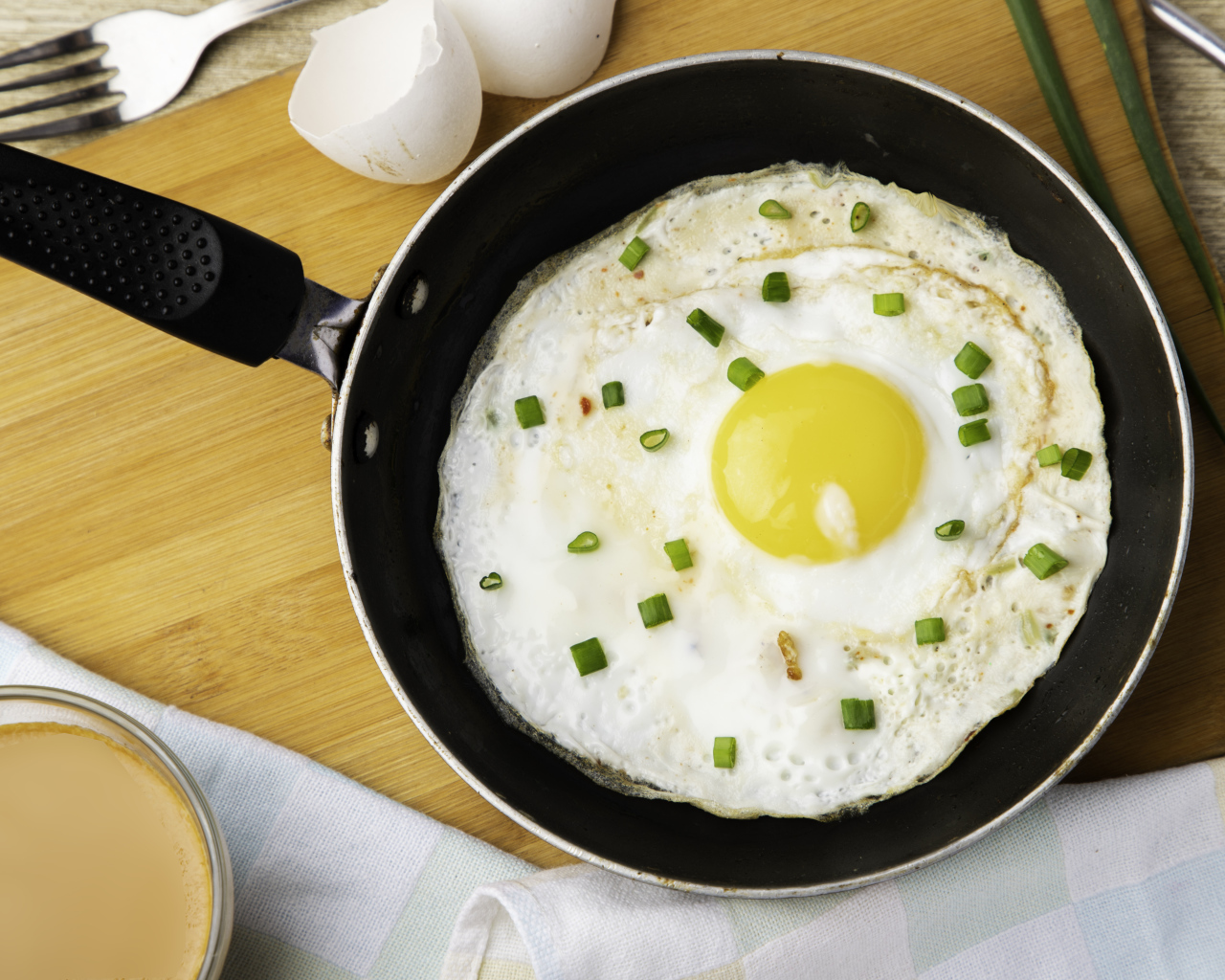 Яичница глазунья на сковороде с зеленым луком