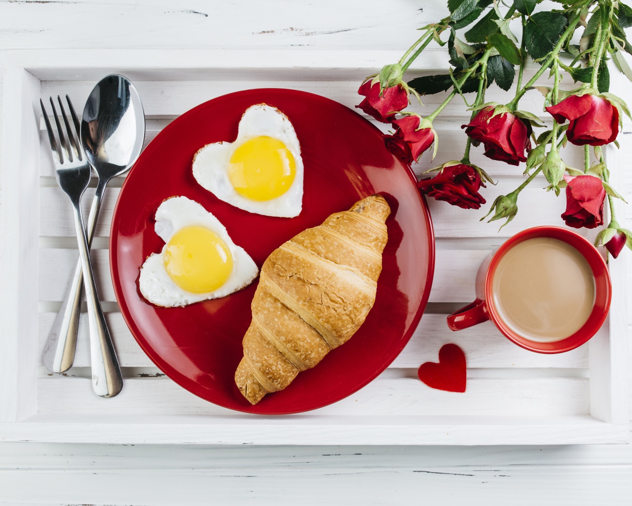 Яичница с круассаном на красной тарелке на столе букетом роз и чашкой какао