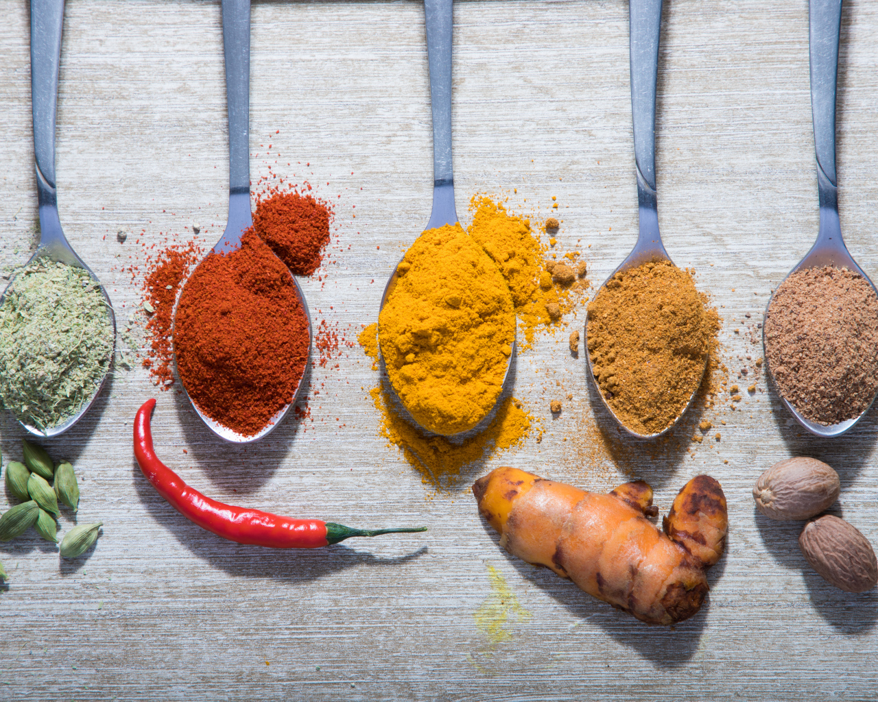 Молотые специи в ложках на столе 