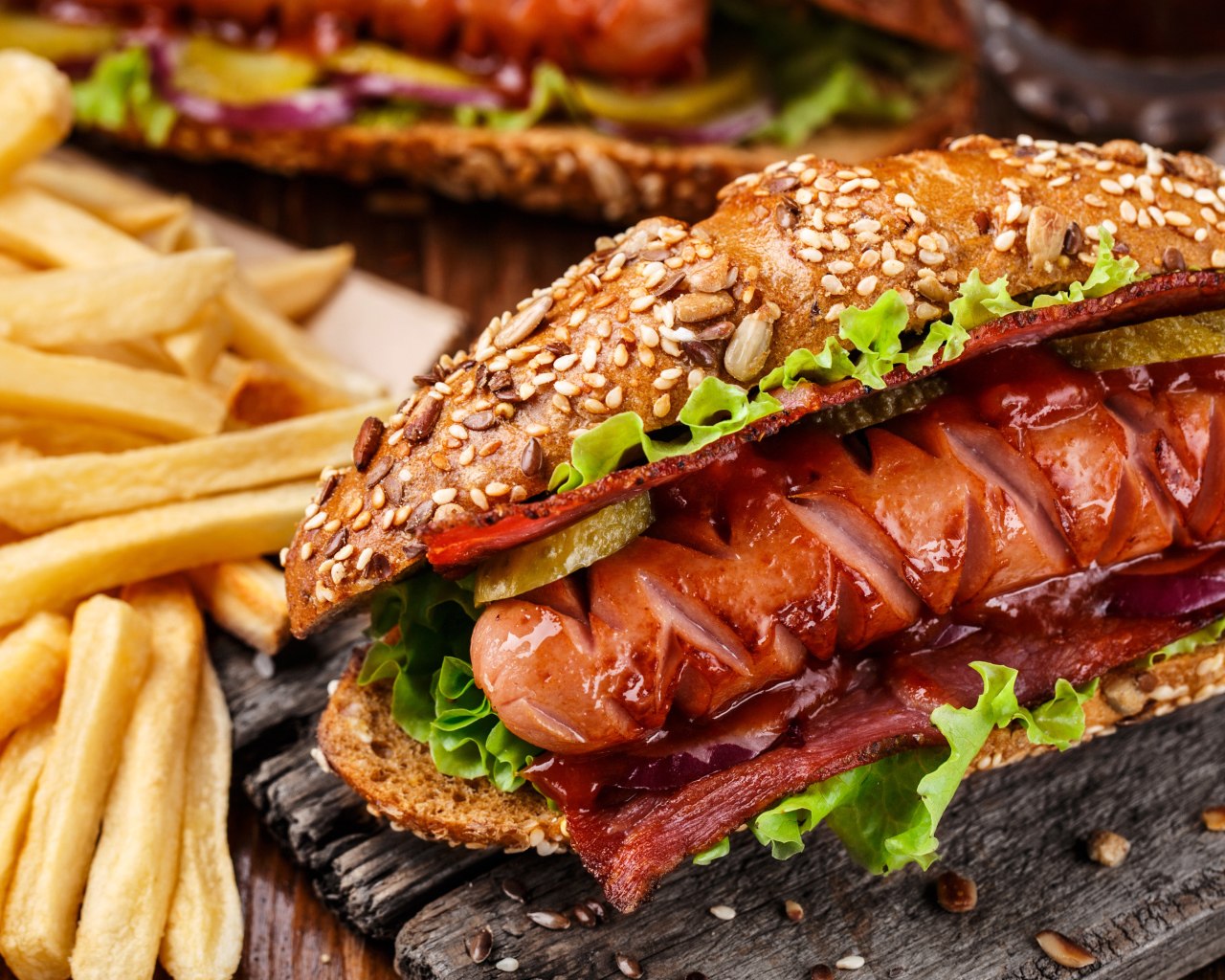 Хотдог с сосиской и беконом на столе с картофелем фри 