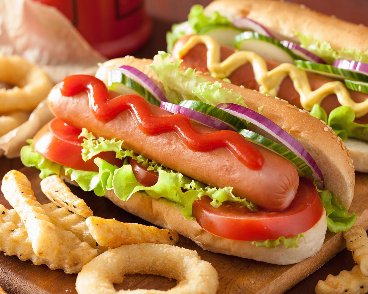 Хотдоги с овощами на разделочной доске с картофелем фри