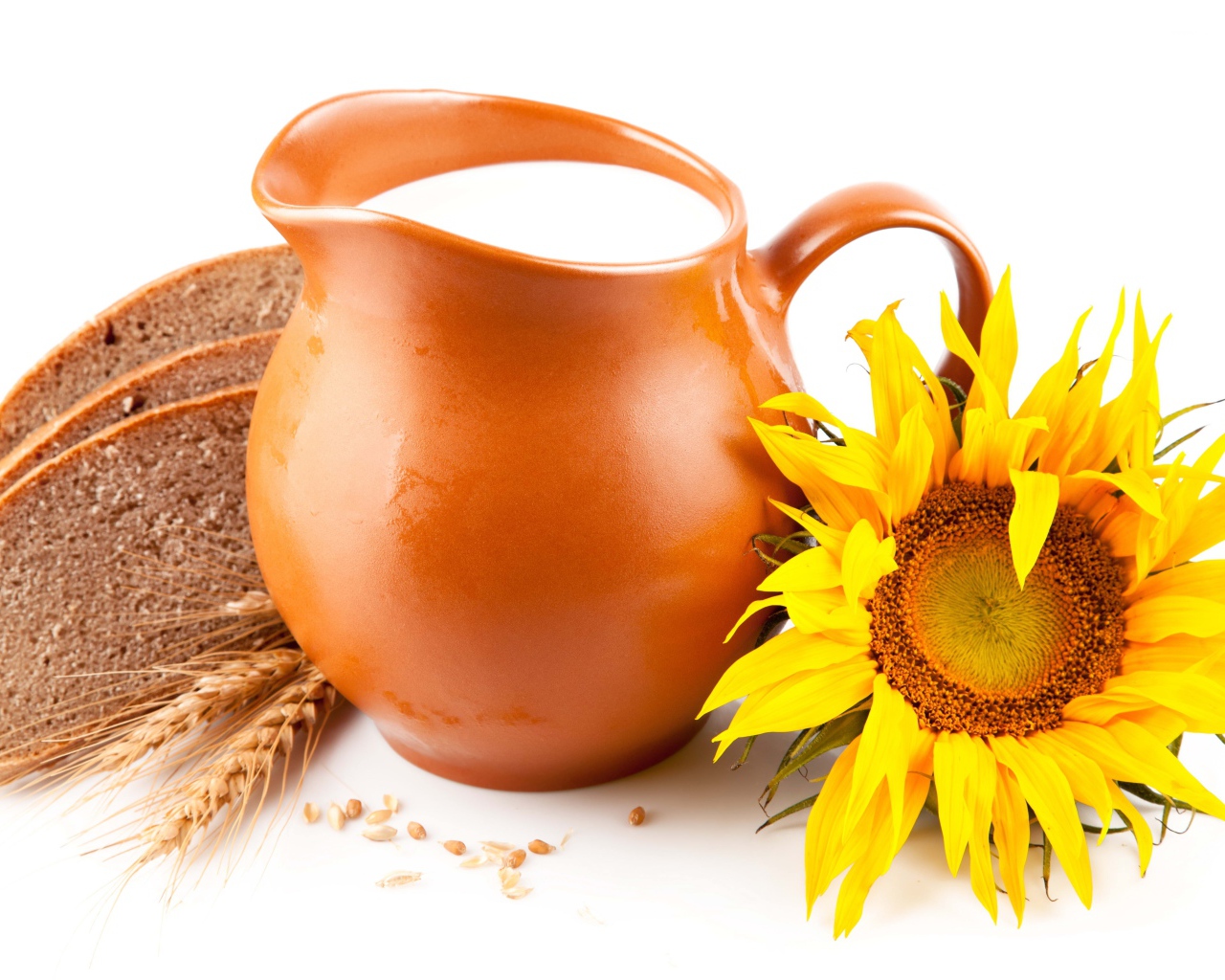 Кувшин с молоком на белом фоне с хлебом и подсолнухом