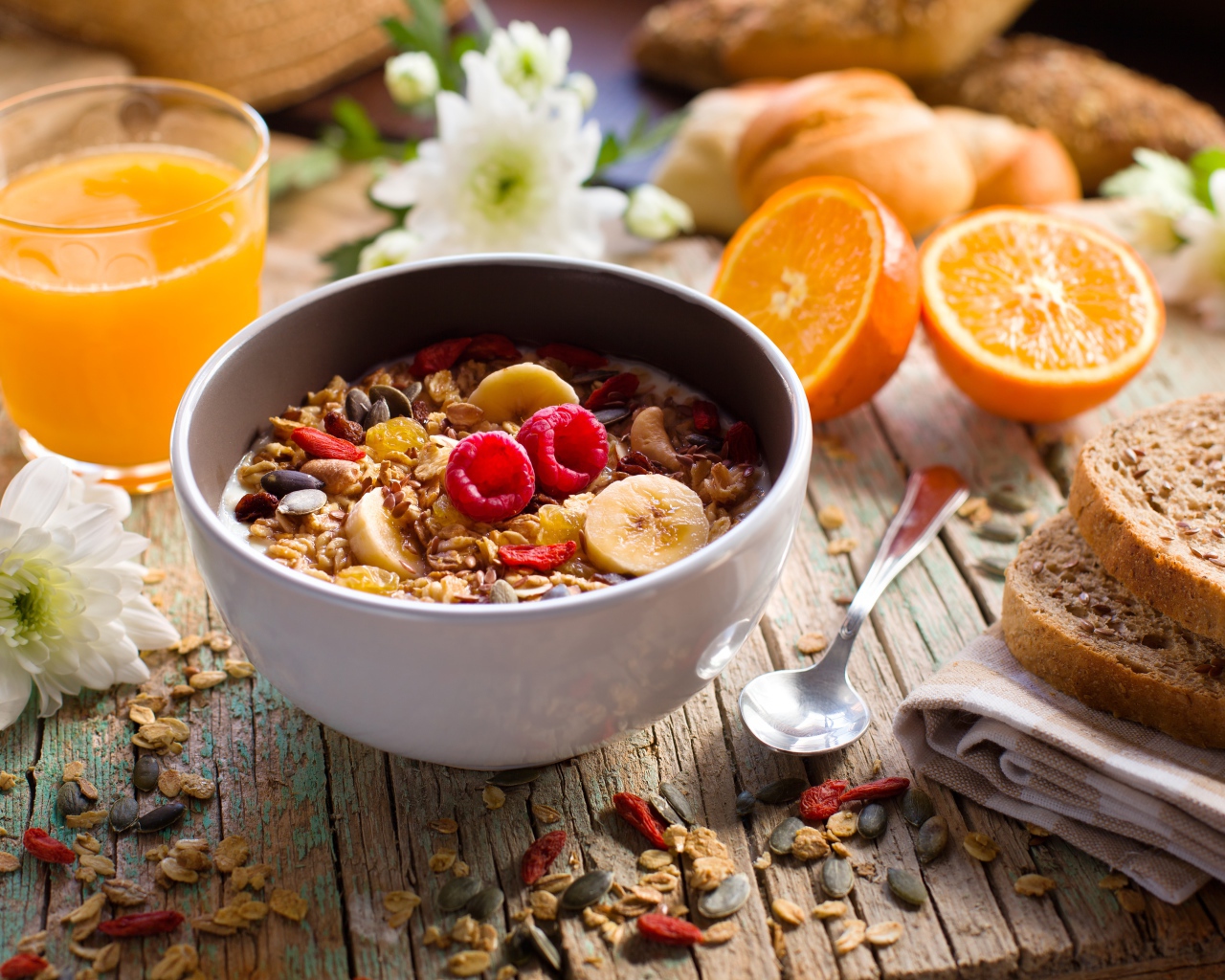 Мюсли в миске с молоком на завтрак с соком и апельсинами 