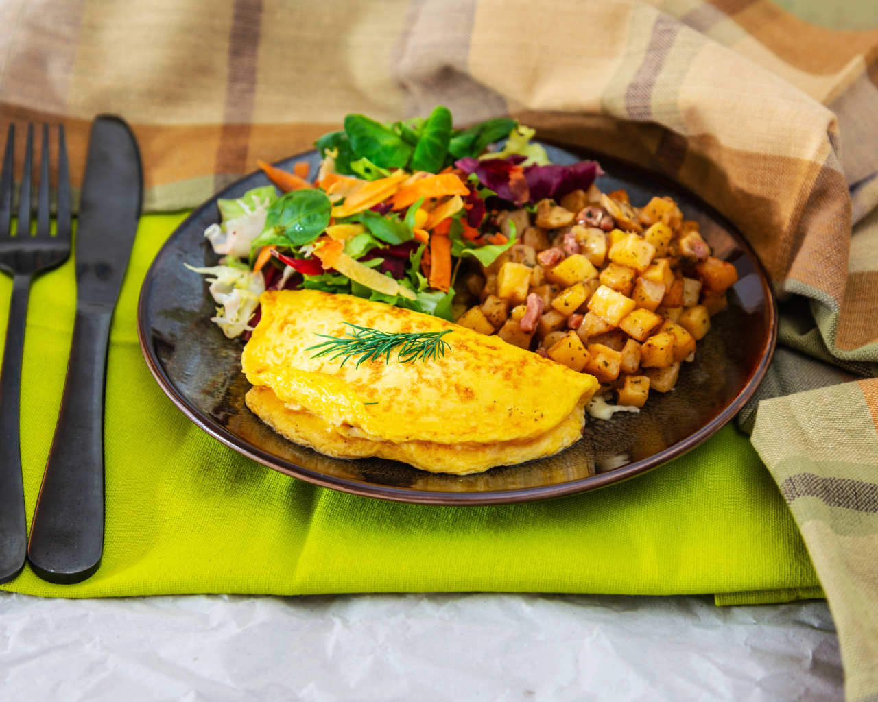 Омлет на тарелке с салатом и овощами