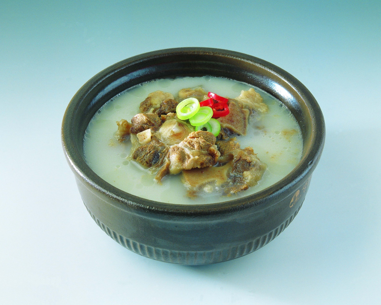 Тарелка супа с говядиной  на голубом фоне