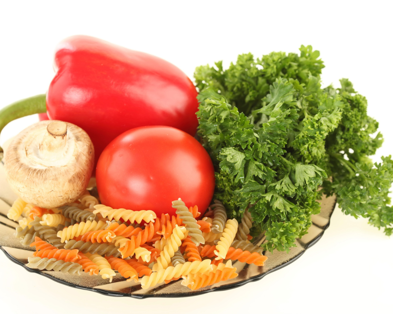 Тарелка с макаронами, красным перцем, помидором, шампиньоном и зеленью петрушки