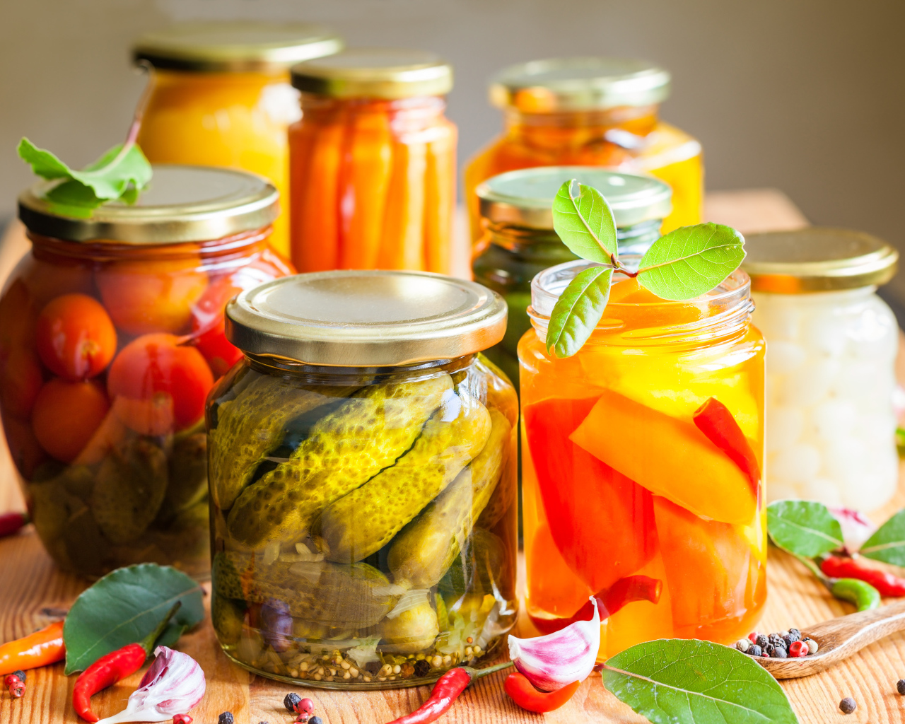 Консервация в стеклянных банках на столе со специями