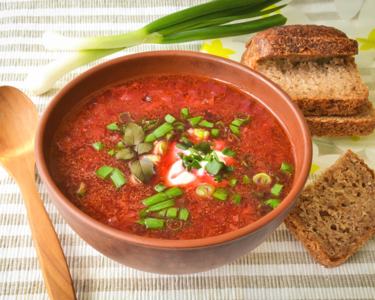 Красный борщ с луком на столе с хлебом 