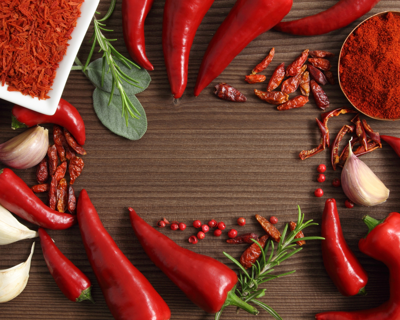 Красный перец с чесноком на деревянном столе