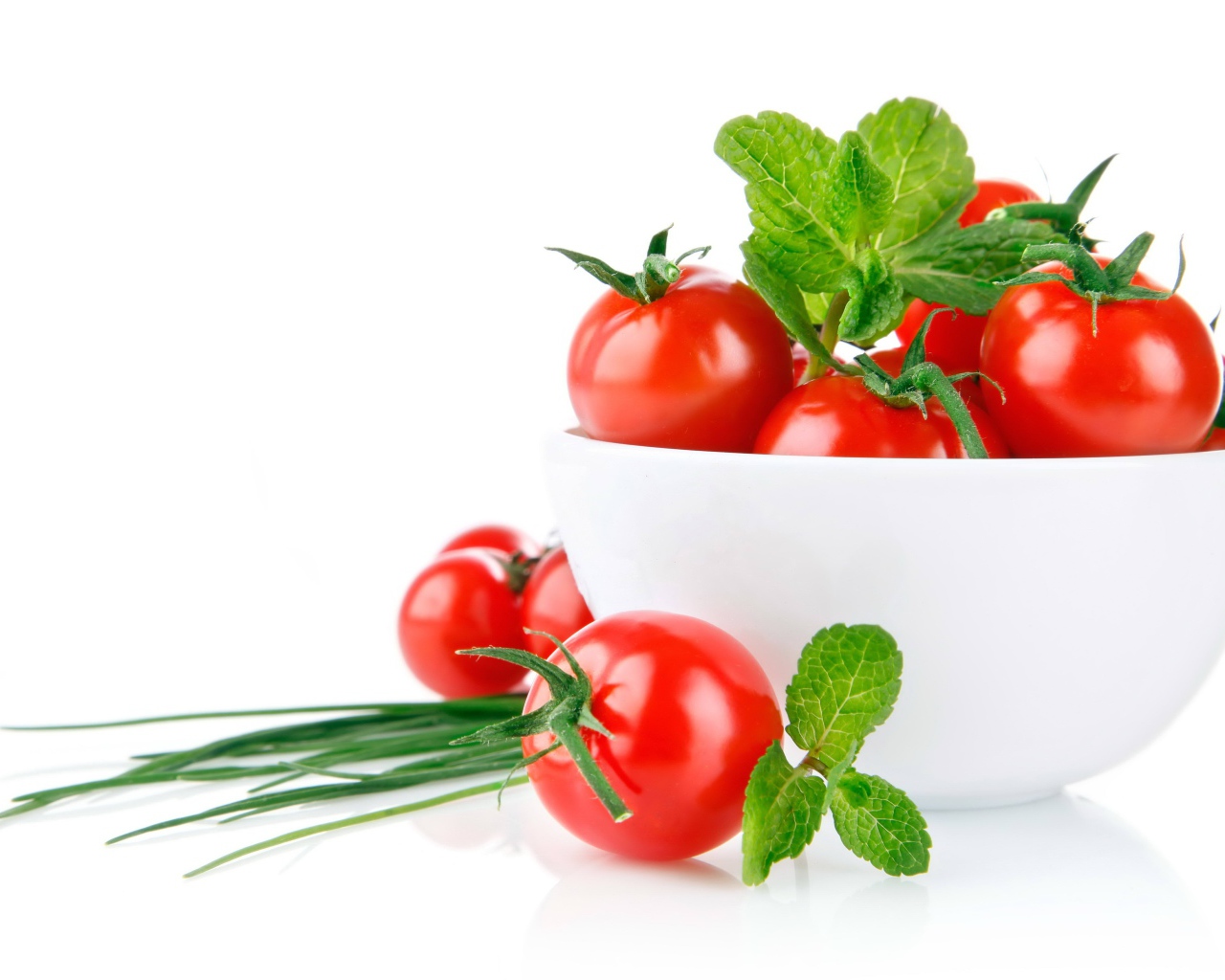 Красные помидоры с зеленым луком на белом фоне